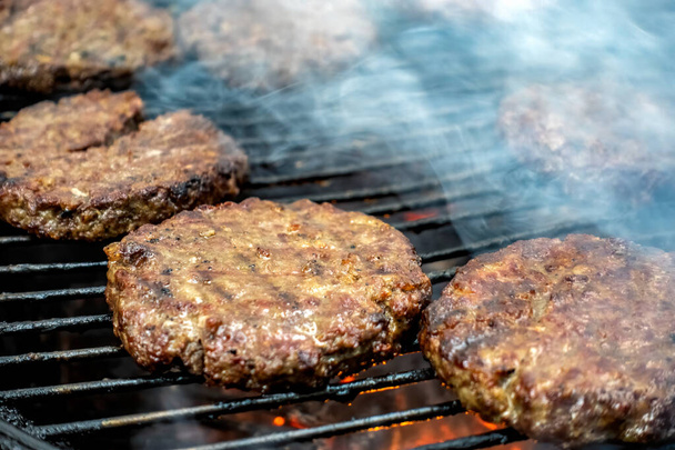 Juicy meat steaks cooked over charcoal on a wire rack. Meat cooked on a fire in the open air. Selective focus. Close-up. - Foto, imagen