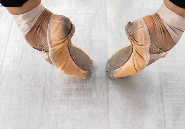 Close up of ballerina's leg, she is standing on stair outside wearing pointe shoes. - Photo, Image