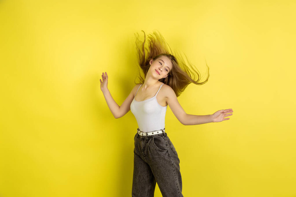 Caucasian young girls portrait isolated on yellow studio background. Beautiful female model. Concept of human emotions, facial expression, sales, ad, youth culture. - Фото, изображение