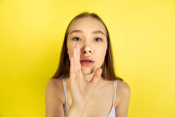 Caucasian young girls portrait isolated on yellow studio background. Beautiful female model. Concept of human emotions, facial expression, sales, ad, youth culture. - 写真・画像