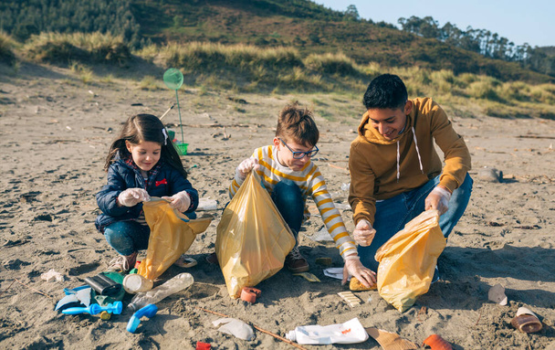 Junge Freiwillige säubern den Strand - Foto, Bild