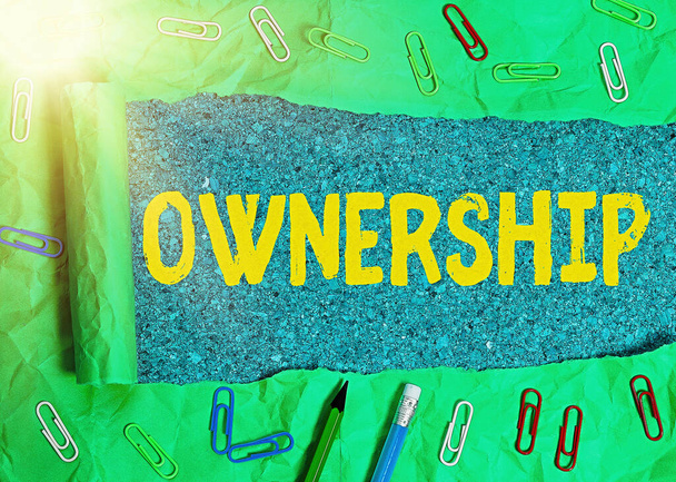 Text sign showing Ownership. Conceptual photo the state, relation, or fact of being an owner or with a group Rolled ripped torn cardboard placed above a wooden classic table backdrop. - Photo, Image