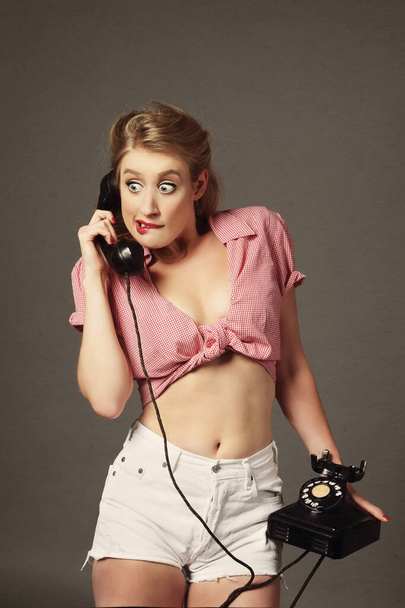 portrait of a young attractive blonde sexy vintage pin-up woman phoning on isolated studio background - Fotoğraf, Görsel