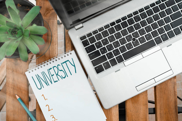 Handwriting text University. Concept meaning institution of higher learning providing facilities for teaching Personal workplace overview with laptop device used for individual interest. - Photo, Image