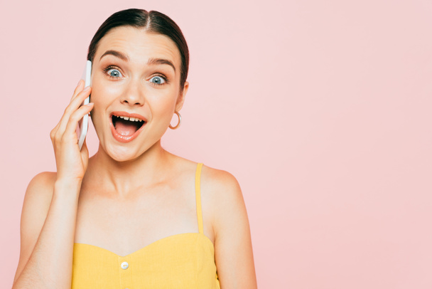 izgatott barna fiatal nő beszél okostelefon elszigetelt rózsaszín - Fotó, kép
