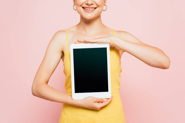 oříznutý pohled mladé ženy držící digitální tablet s prázdnou obrazovkou na růžové - Fotografie, Obrázek
