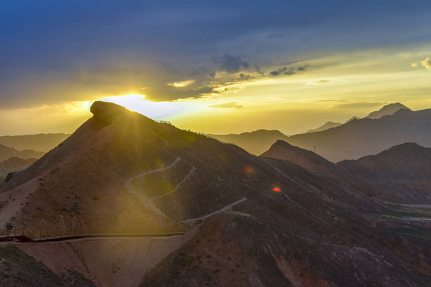 Increíble paisaje de la montaña del arco iris y el fondo del cielo azul en la puesta del sol. Zhangye Danxia National Geopark, Gansu, China. Paisaje colorido, colinas del arco iris, rocas de colores inusuales, erosión de piedra arenisca - Foto, imagen