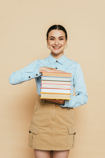 student in denim shirt with books on beige - Foto, imagen