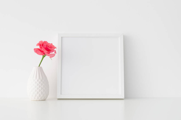 Λευκό τετράγωνο πλαίσιο mockup με ροζ τριαντάφυλλο σε ένα βάζο. - Φωτογραφία, εικόνα