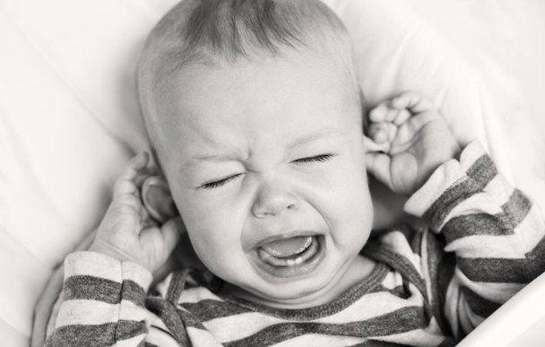 ładny mały chłopiec płacze, trzymając jego ucho - Zdjęcie, obraz