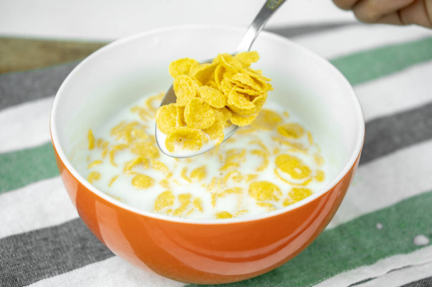 droge cornflakes in een kom met melk, gezonde voeding - Foto, afbeelding