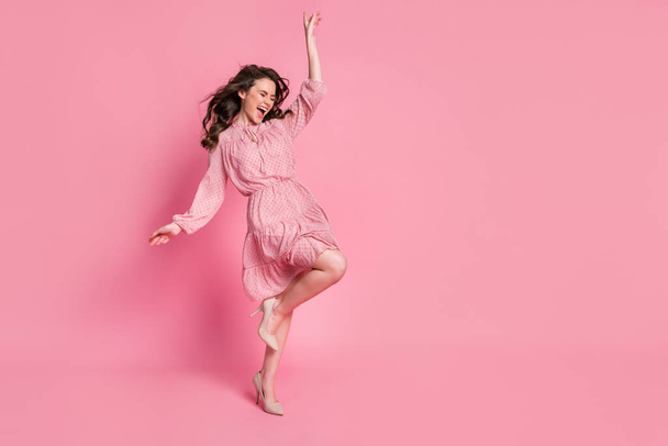 Full body photo of crazy excited girl enjoy rejoice haircut air wind blow fly close eyes raise hand leg isolated over pink color background - Fotoğraf, Görsel