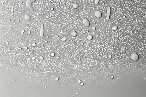 Gran cantidad de gotas de agua. Textura de fondo abstracta. Cascadas sobre un fondo sólido, recogiendo burbujas sobre una superficie limpia. Gotas de lluvia, una serie de fotografías naturales
 - Foto, Imagen