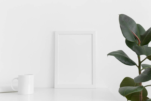 Fehér vázlatkép egy bögrével, könyvvel és fikusszal egy fehér asztalon. Portré orientáció. - Fotó, kép