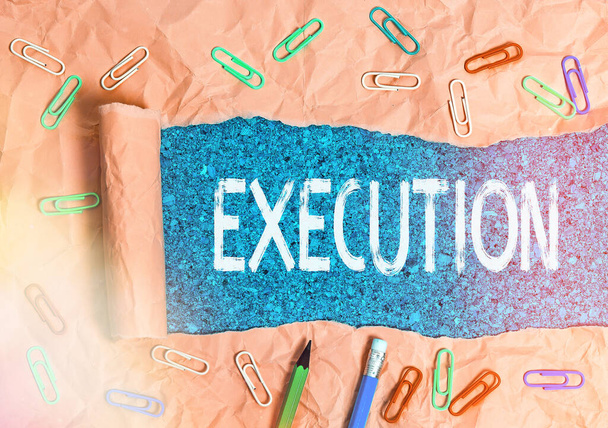Text sign showing Execution. Conceptual photo the carrying out or putting effect of plan, or course of action Rolled ripped torn cardboard placed above a wooden classic table backdrop. - Photo, Image