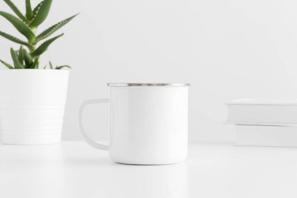 Enamel mug mockup with a aloe vera in a pot and books on a white table. - Fotografie, Obrázek