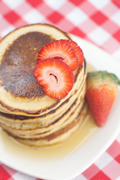 Pancakes, honey and strawberry on checkered fabric - Фото, зображення