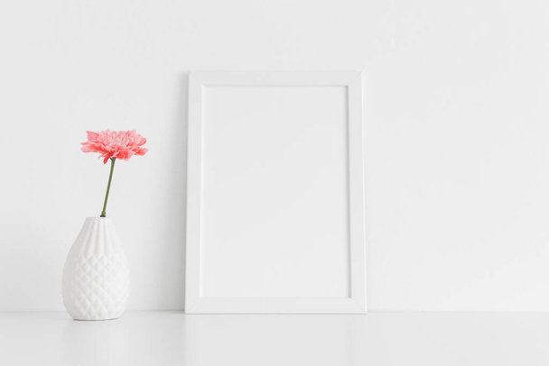Marco blanco maqueta con un crisantemo en un jarrón en una mesa blanca. Orientación vertical
. - Foto, imagen
