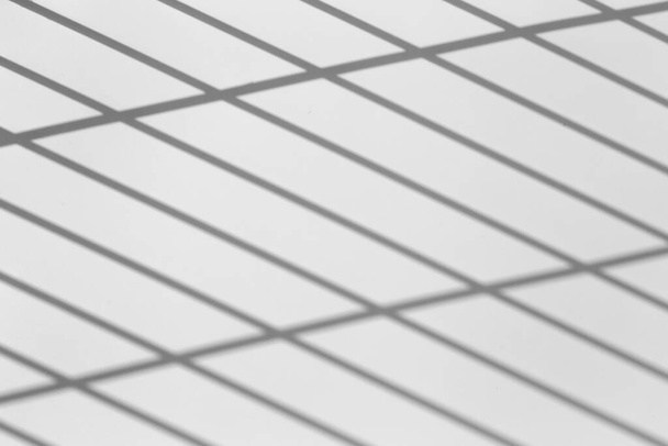 Efeito de sobreposição de sombra para foto. Sombras de linhas de grade ou grade de uma cerca ou guardrail em uma parede branca limpa em um dia claro ensolarado. Sombras geométricas - Foto, Imagem