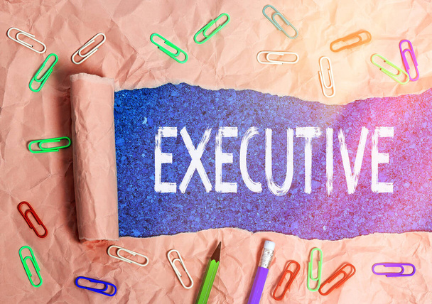 Text sign showing Executive. Conceptual photo belonging to the branch of government that is charged with powers Rolled ripped torn cardboard placed above a wooden classic table backdrop. - Photo, Image