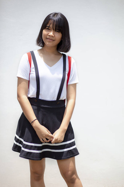 retrato bastante asiático adolescente de pie contra blanco pared
  - Foto, imagen