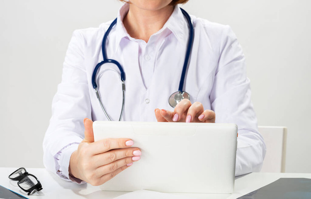 Close up female doctor hands using tablet computer - Φωτογραφία, εικόνα