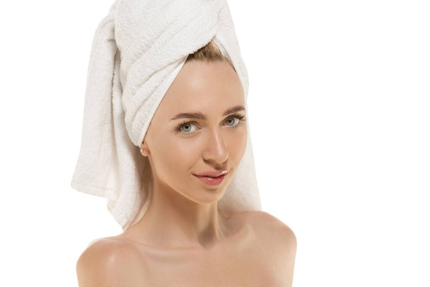 Beauty Day. Woman wearing towel doing her daily skincare routine. Portrait isolated on white studio background - Foto, Imagen