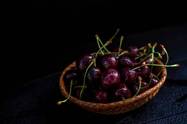 Ripe cherries on a black background - Fotó, kép