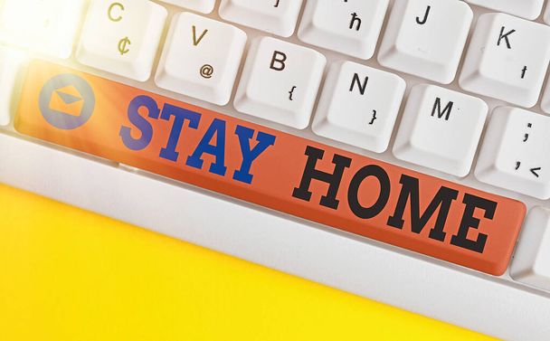 Conceptual hand writing showing Stay Home. Business photo showcasing not go out for an activity and stay inside the house or home Colored keyboard key with accessories arranged on copy space. - 写真・画像