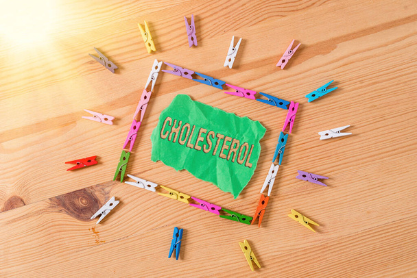 Conceptual hand writing showing Cholesterol. Business photo showcasing compound of the sterol type found in most body tissues Colored crumpled papers wooden floor background clothespin. - Photo, Image