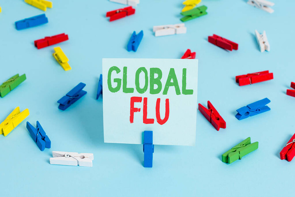 A globális influenzát mutató feljegyzés. Üzleti fotó bemutatása Közönséges fertőző betegség terjed szerte a világon gyorsan színes ruhacsap papírok üres emlékeztető kék padló officepin. - Fotó, kép