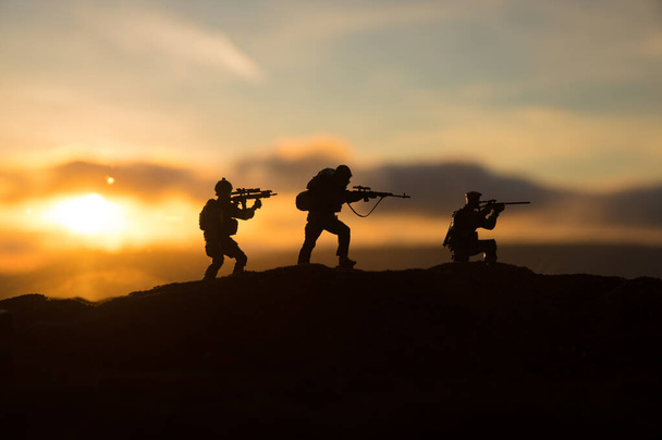 War Concept. Military silhouettes fighting scene on war fog sky background, World War Soldiers Silhouette Below Cloudy Skyline sunset. Selective focus - Photo, Image