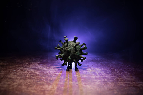 Coronavirus 2019-nCov πρωτότυπο concept coronavirus. Μεγάλο Corona ιός μινιατούρα μοντέλο σε ξύλινο τραπέζι με ομίχλη και backlight. Δημιουργική διακόσμηση έργων τέχνης. Επιλεκτική εστίαση. - Φωτογραφία, εικόνα