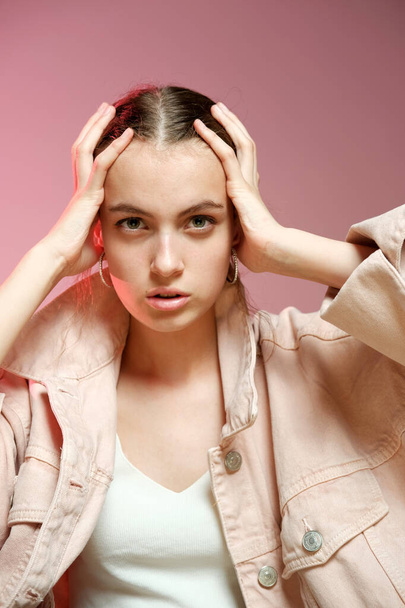 A girl in a pink denim shows different emotions and poses on a pink background. - Φωτογραφία, εικόνα