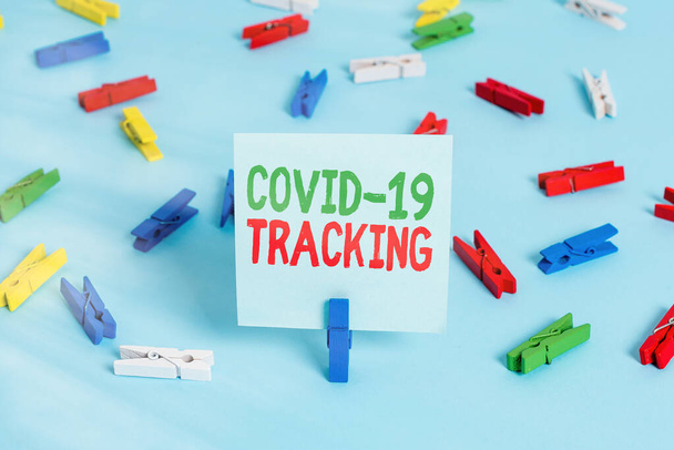 Covid 19 Trackingを示すライティングノート。感染の可能性のある個人の識別プロセスを示すビジネス写真色の布紙空のリマインダ青の床オフィピン. - 写真・画像