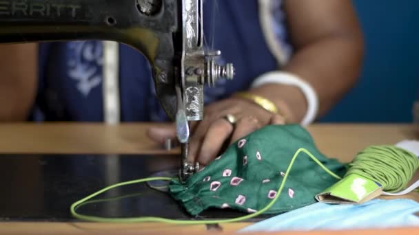 Indiase vrouw werkt aan oude naaimachine - het maken van zelfgemaakte gezichtsmaskers tegen coronavirus of covid19 verspreiding, close-up detail op bewegende naald en vingers houden stof - Video