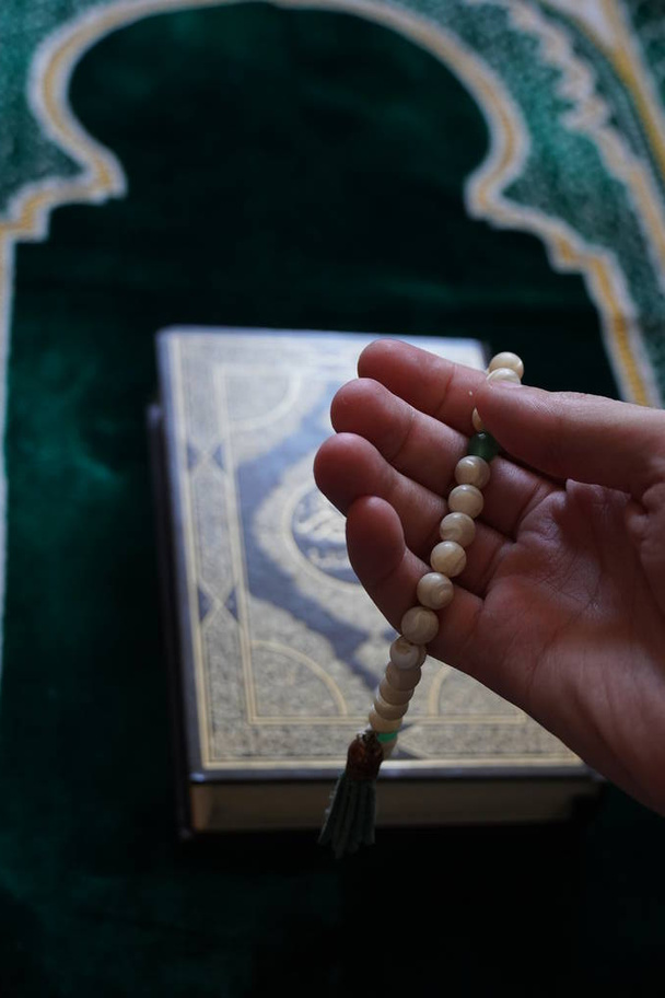 Tespih en la mano, un Corán en el fondo
 - Foto, imagen
