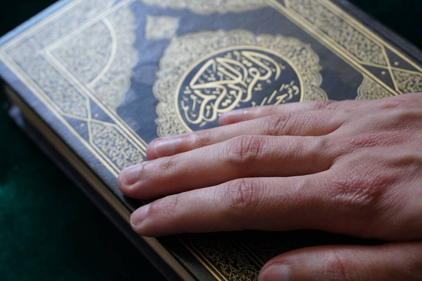 Ręka na świętą księgę Koranu, Kuranie. - Zdjęcie, obraz