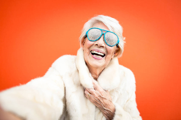 Funny grandmother dancing on colored background - Foto, imagen