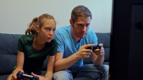 Papa en zijn dochter spelen console spel met draadloze joysticks. - Video