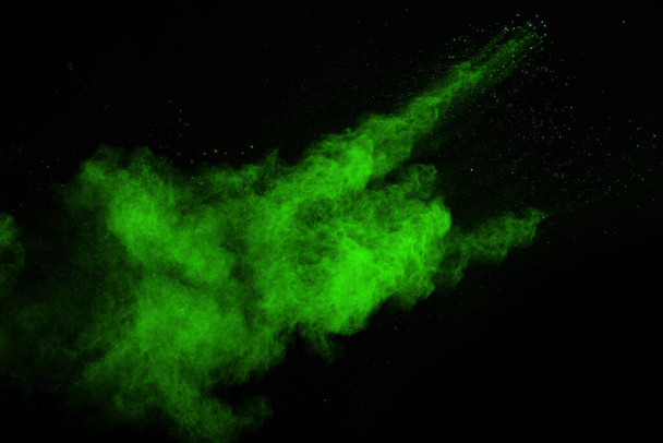 The movement of abstract dust explosion frozen green on black background. Stop the movement of powdered green on black background. Explosive powder green on black background. - Photo, Image