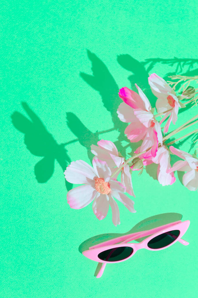 Стильні літні аксесуари сонцезахисні окуляри та квіти. Концепція модного натюрморту
 - Фото, зображення