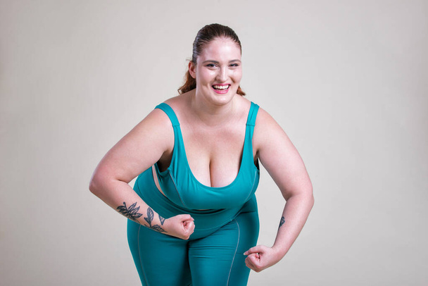 Plus size woman making sport and fitness. Studio portraits with curvy girl - Zdjęcie, obraz