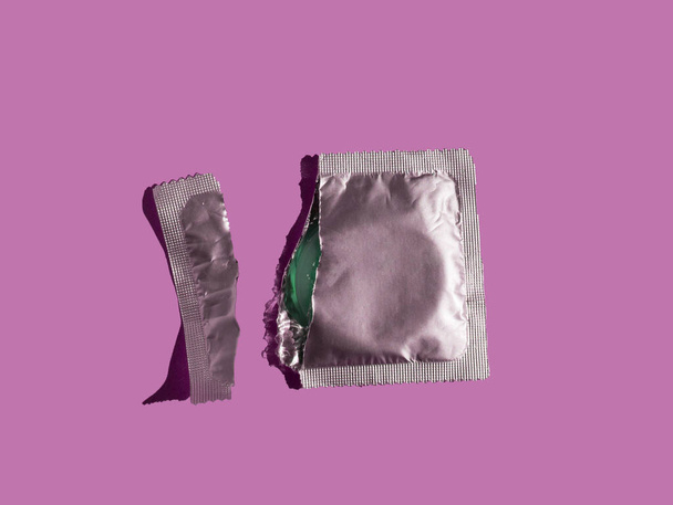 pattern for health protection from HIV, sexually transmitted diseases and unwanted pregnancy. Top view. Pattern made from silver condoms on color background. Safe sex concept - Photo, Image