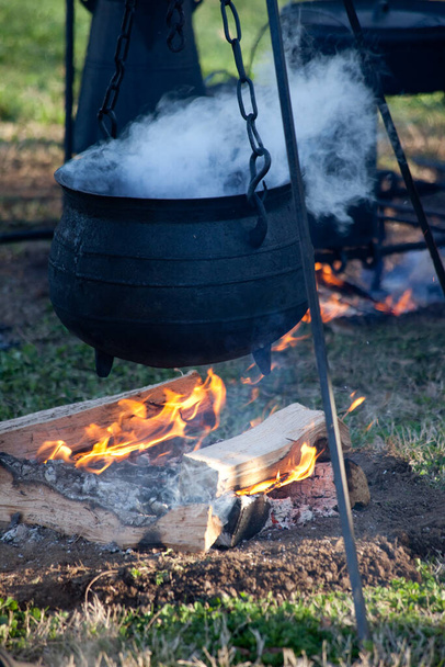 火の上で鋳鉄で調理する - 写真・画像