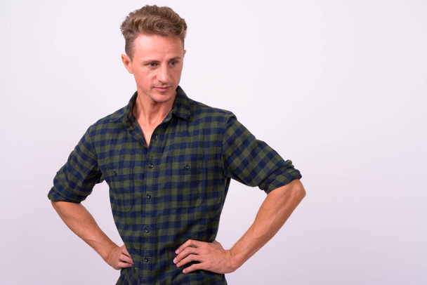 Studio shot of handsome man with blond curly hair wearing green checkered shirt  - Photo, Image