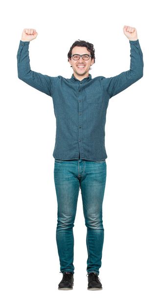 Full length portrait of successful businessman, wearing eyeglasses, raising hands over head, celebrating victory. Self overcome concept and success achievement. Contented person isolated on white. - Photo, Image