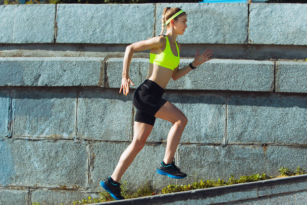 Female runner, athlete training outdoors in summers sunny day. - Foto, afbeelding