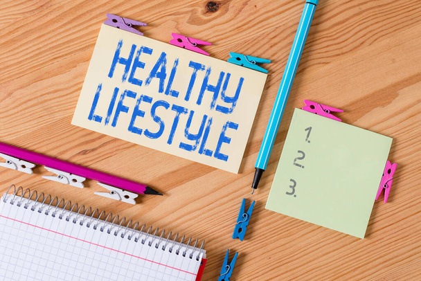 Conceptual hand writing showing Healthy Lifestyle. Business photo showcasing way of living that lowers the risk of being seriously ill Colored crumpled papers wooden floor background clothespin. - Photo, Image