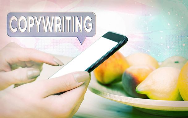 Word writing text Copywriting. Business concept for writing the text of advertisements or publicity material Modern gadgets with white display screen under colorful bokeh background. - Photo, Image